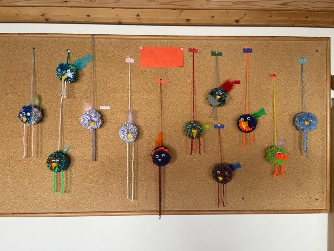 Auf dem Bild sieht man kleine Pomponvögel aus Wolle