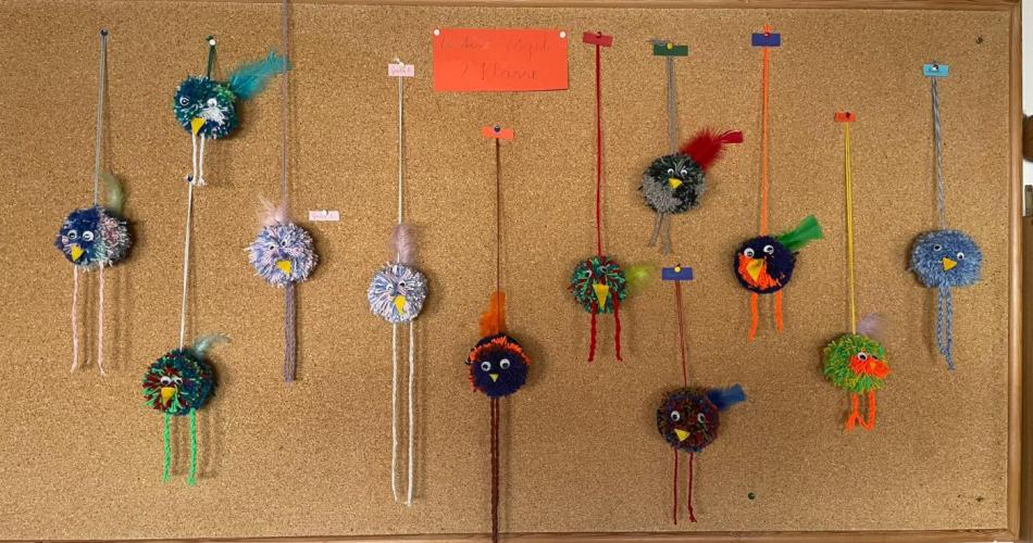 Auf dem Bild sieht man kleine Pomponvögel aus Wolle