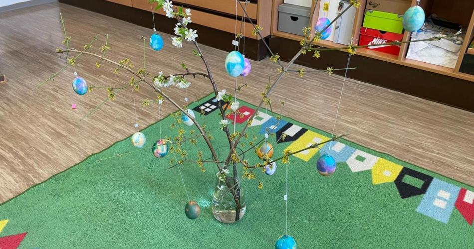 Ein Bild von einem Osterstrauch, an dem bunte Ostereier hängen